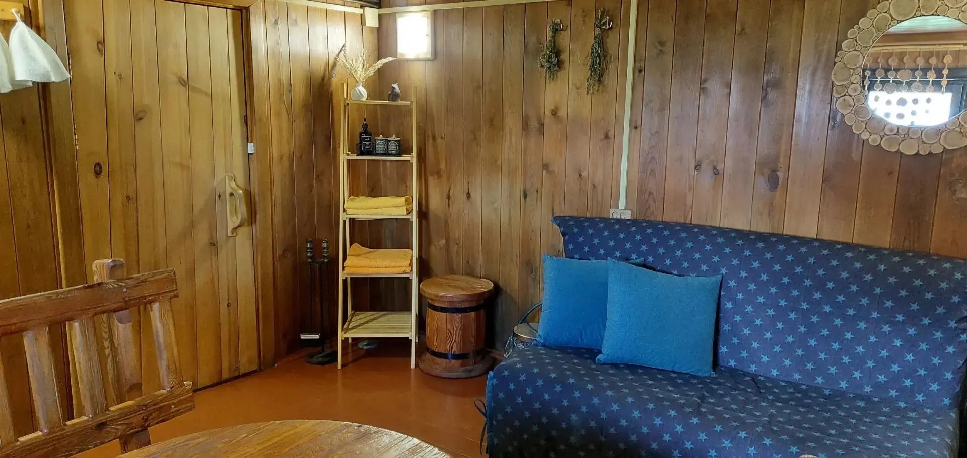 Cozy corner with wooden walls, a sofa, and a table.