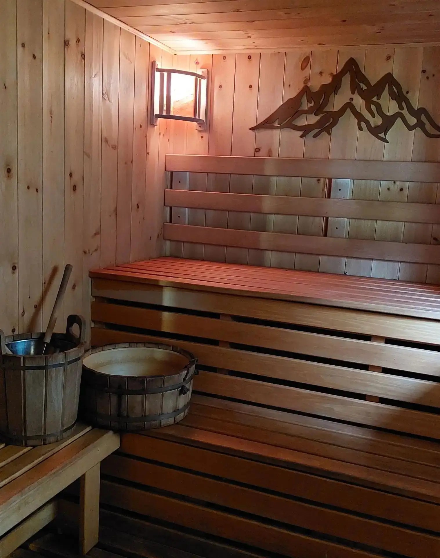 Wooden sauna with benches and water buckets