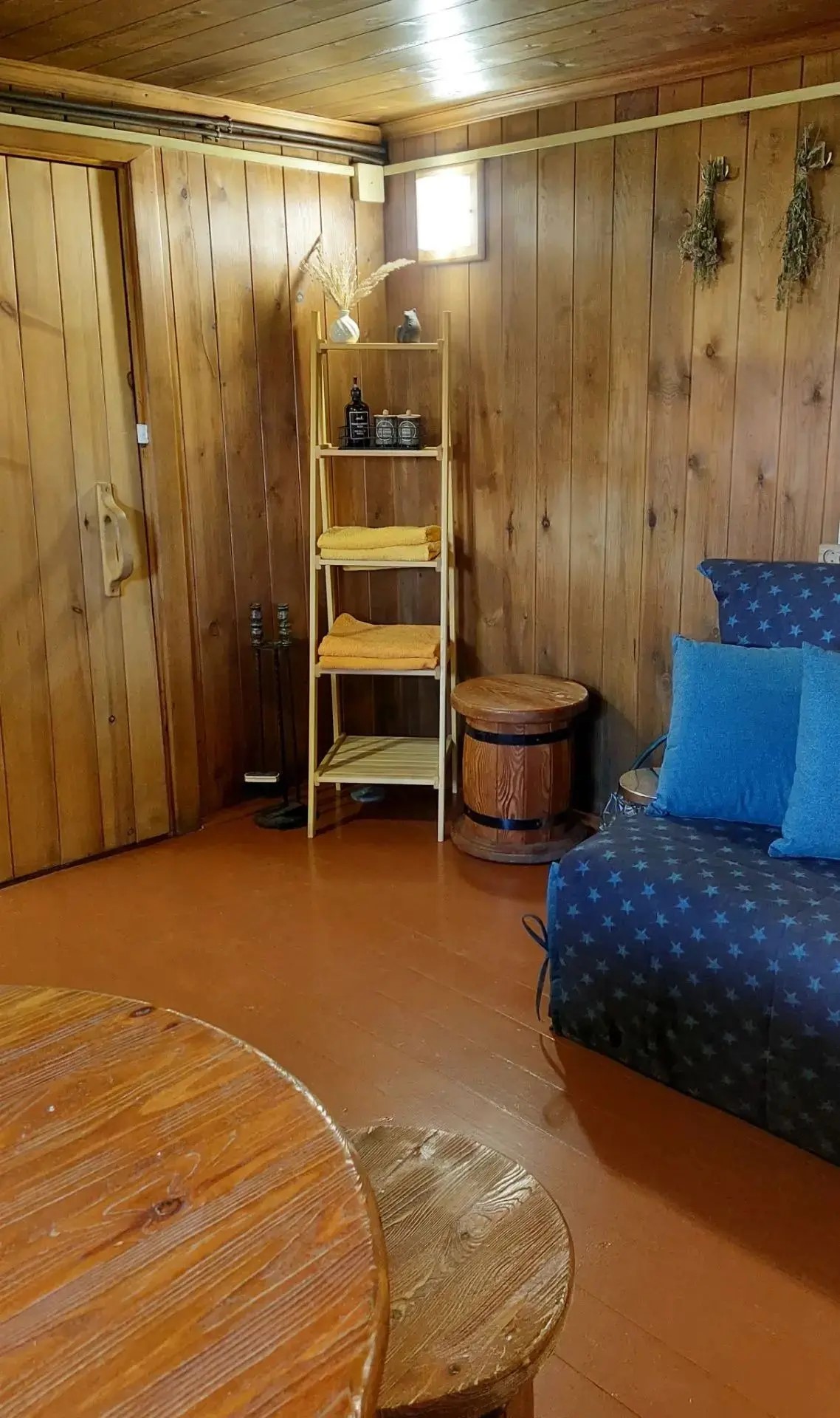 Cozy room with wooden walls, furniture, and accessories.